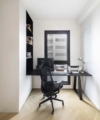 חדר עבודה מעוצב עם שולחן עבודה רחב וארוך, המשלב נגיעות אלגנטיות של שחור בגופי תאורה ובפרטי עיצוב שונים, ליצירת סביבה נוחה ויצירתית.