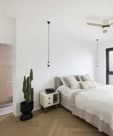 חדר שינה הורים מרווח ומעוצב, הכולל מיטה זוגית גדולה עם טקסטיל עשיר וארון קיר מותאם אישית שיוצר מראה אלגנטי ופתרון אחסון יעיל.