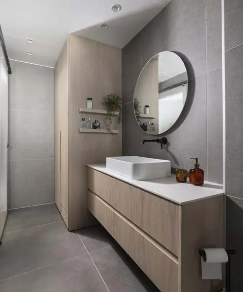 חדר רחצה הורים בעיצוב יוקרתי עם ארון כיור מודרני עשוי עץ אלון מולבן, מראה גדולה ומפנקת מעל הכיור.