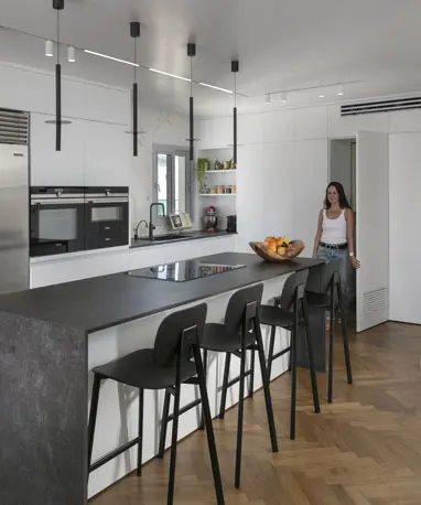 מטבח בדירת יוקרה עם נגרות אחידה ודלת נסתרת לחדר שירות