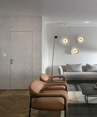 אזור ישיבה בסלון דירת יוקרה בתל אביב, עם תאורה דקורטיבית וקיר מעוצב