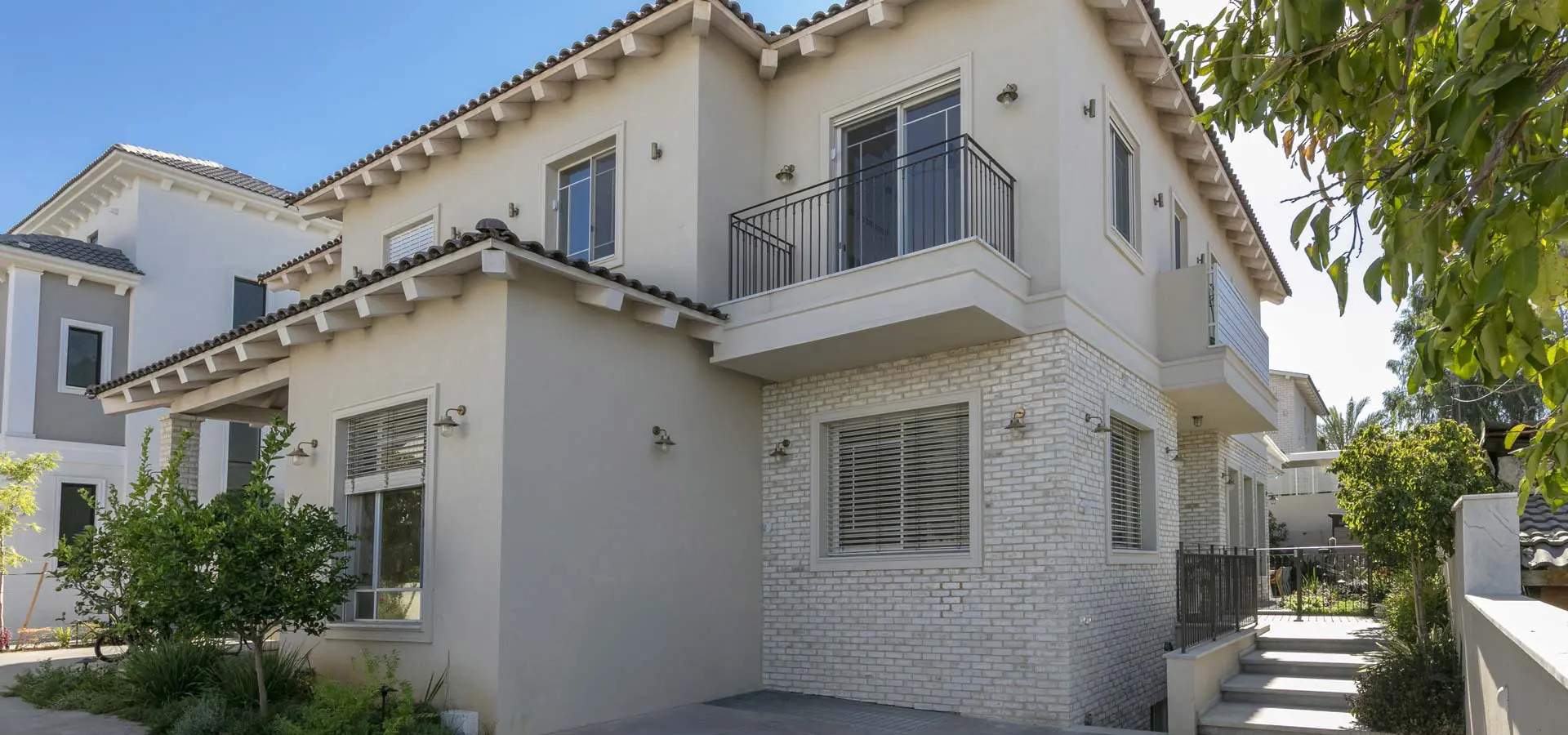 בית פרטי חדש בפתח תקווה בסגנון כפרי עם חיפוי בריקים ופתחים רחבים