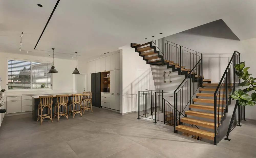 מטבח ופינת אוכל בבית פרטי עם מדרגות ברזל ושלבי עץ, תקרת גבס מונמכת וריצוף גדול בגוון בטון