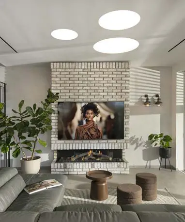 קיר בריקים עם קמין מובנה מתחת לטלוויזיה, לצד פתיחה גדולה לרחבת הגינה