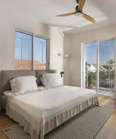 חדר הורים כפרי-לייט עם ריצוף עץ, מאוורר תקרה ופתיחה למרפסת חיצונית