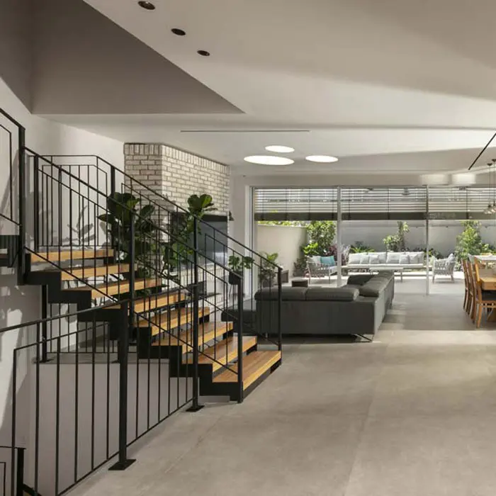 חלל מגורים מרווח עם מדרגות, פינת אוכל וחיבור פתוח לחצר בעיצוב פנים מודרני