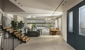 חלל מגורים מרווח עם מדרגות, פינת אוכל וחיבור פתוח לחצר