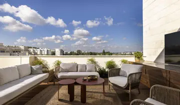 מרפסת פנטהאוז מעוצבת עם פינת ישיבה ונוף